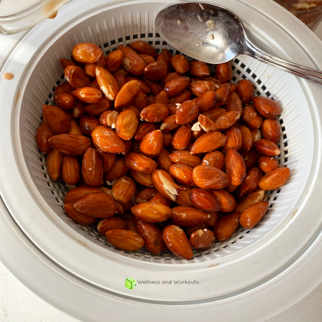 Soaked almonds being strained in a colander and bowl set.
