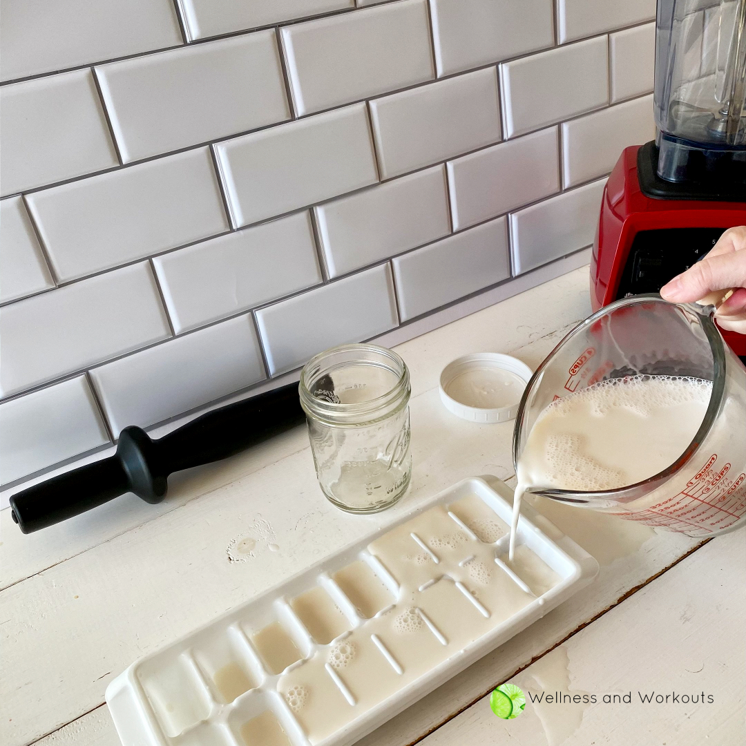 Pouring homemade Vitamix almond milk into ice cube trays to freeze.