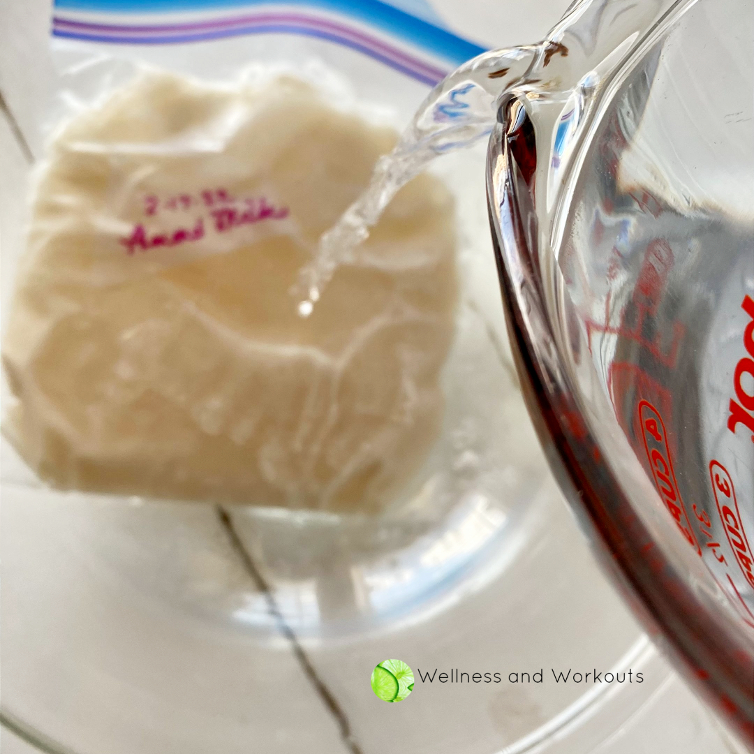 Pouring warm water over a bag of frozen almond milk, in order to defrost it quickly.