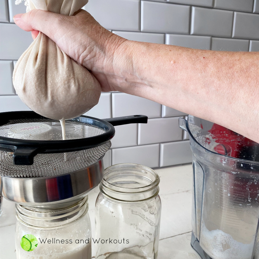 Squeezing a muslin cloth full of wet blended almonds.